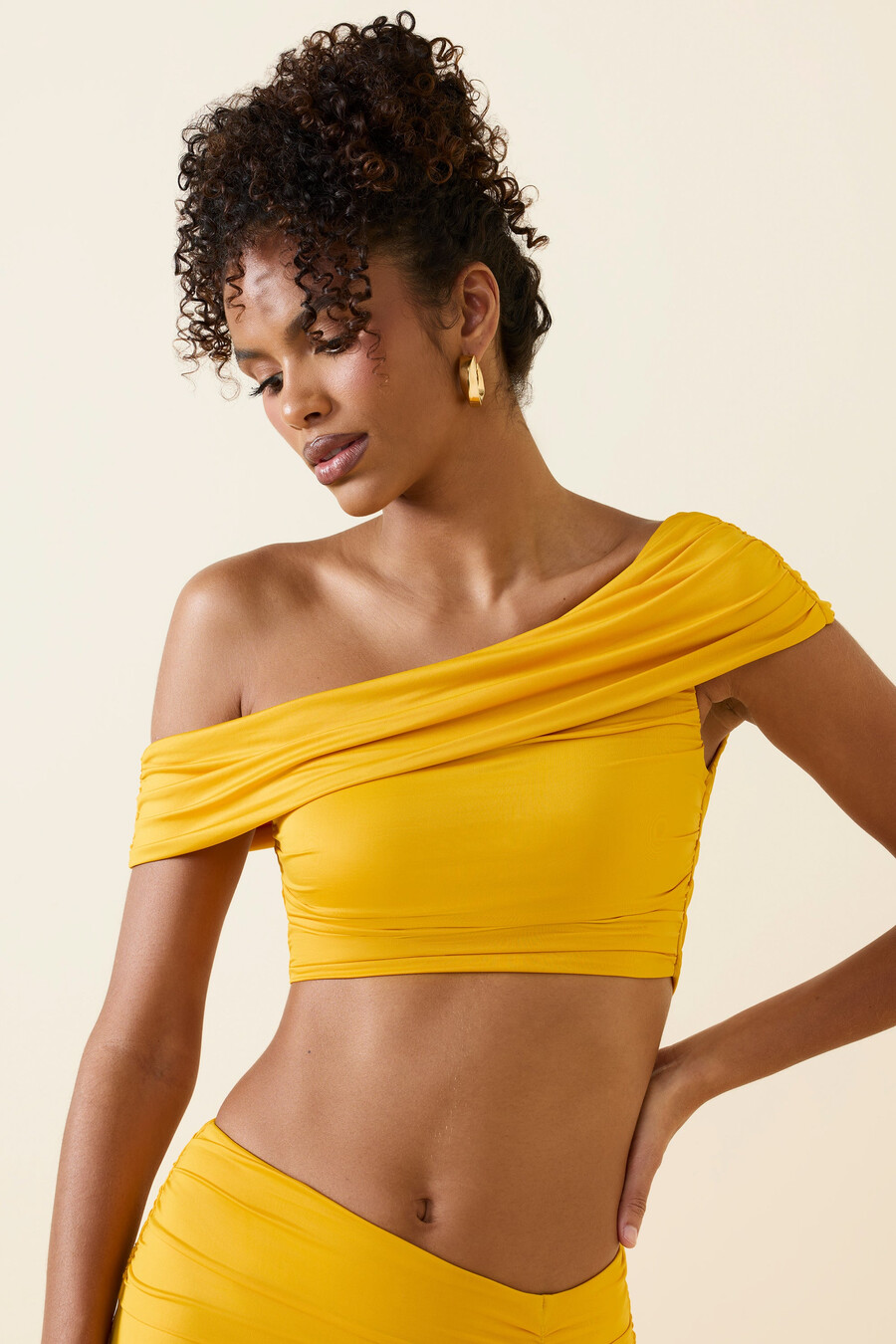 asymetrický nařasený crop top s odhalenými rameny ve zlatavě žluté barvě