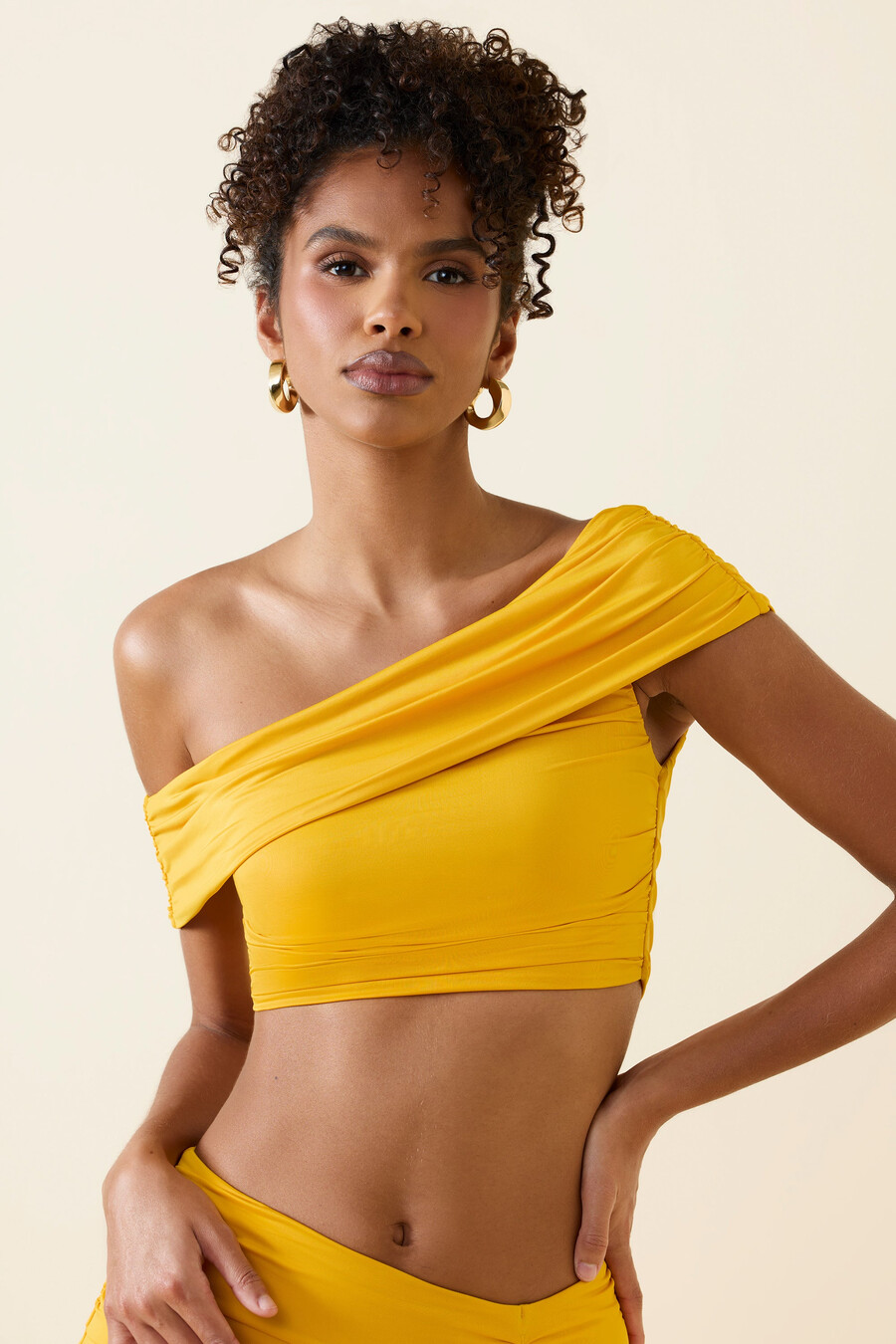 asymetrický nařasený crop top s odhalenými rameny ve zlatavě žluté barvě